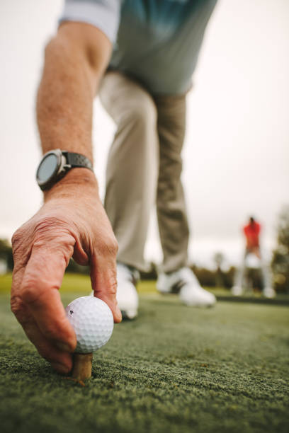istock Golfer placing golf ball on tee at green 1090932686