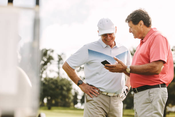 golfistas seniors mirando las puntuaciones en el teléfono después del partido - golf expertise professional sport men fotografías e imágenes de stock