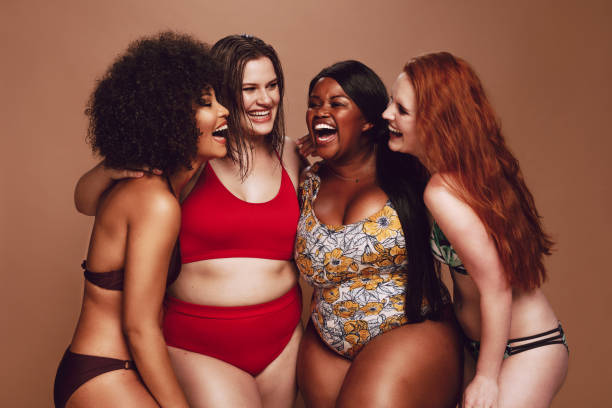 istock Different size females in bikinis laughing together 1090933320