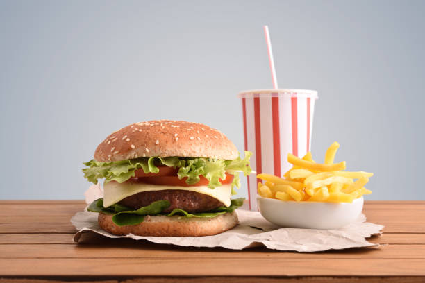istock Beef burger on table with soda and chips gray backgorund 1090940768