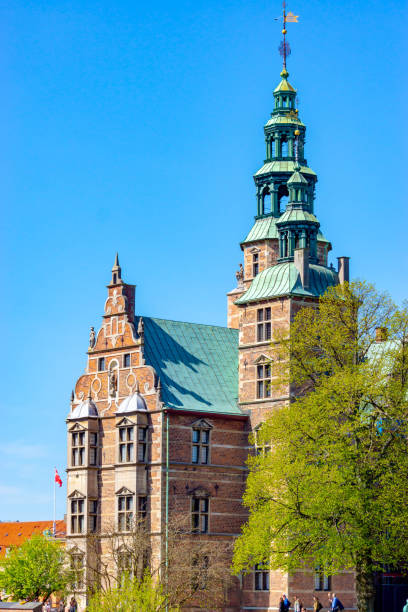 Rosenborg Castle in central Copenhagen, Denmark, was built and extended between 1606 and 1633 in Dutch renaissance style by King Christian IV. In the foreground are trees in Springtime.