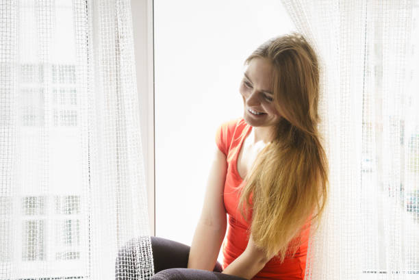 istock Happy woman sitting on windowsill, energizing morning 1090944804