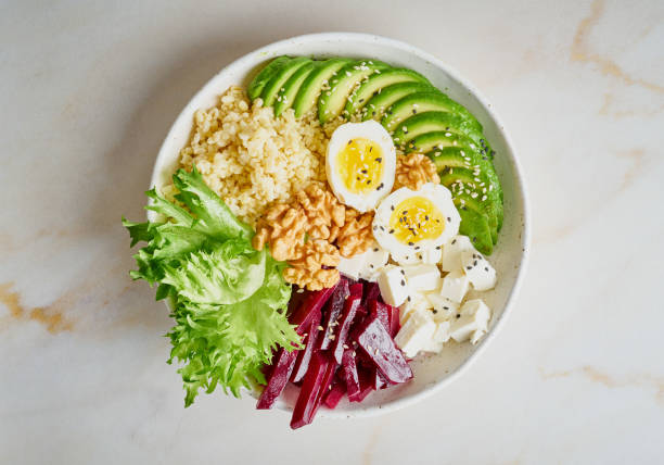 istock Buddha bowl, balanced food, vegetarian menu. Grey marble table, top view. Eggs, avocado, salad lettuce, bulgur, beetroot, tofu. 1090945598