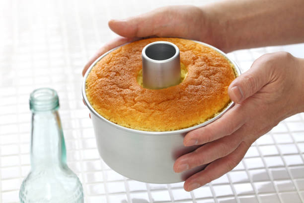 homemade orange chiffon cake cooking, cooling process stock photo