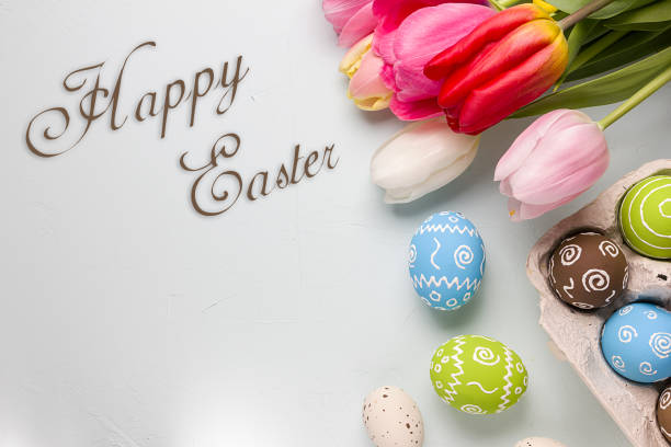 istock Painted easter eggs and bouquet of spring tulips closeup on a light blue background with space for congratulation 1090947906