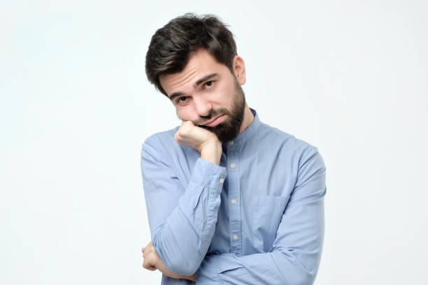 istock Man with beard holding hand on cheek looking tired and sick 1090948048