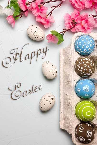 istock Painted easter eggs and branches of spring sakura closeup on a light blue background with space for congratulation 1090948560