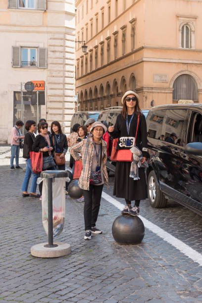 Rome, Italy - April 8, 2017:  A group of tourists of Asian ethnicity on a guided tour in Rome are standing at the Piazza della Minerva next to the Piazza della Rotonda in Rome, Italy, on a morning in spring.
