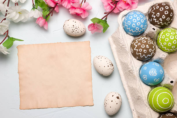 istock Painted easter eggs and branches of spring sakura closeup on a light blue background with space for congratulation 1090948662