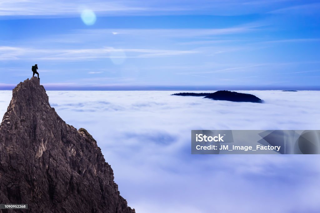 On the Top Hiker at the Top of a Rock enjoying the View on a Sunny Day Cloud - Sky Stock Photo