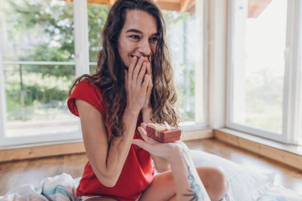 istock Excited young woman receiving present in bed 1090954804