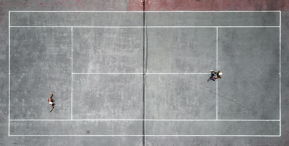 Drone view over tennis court with tow men playing