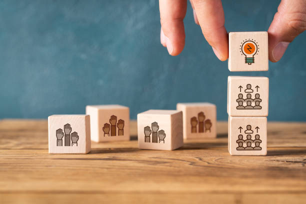 person with the best ideas gets to the top, symbolized by icons on stacked cubes stock photo