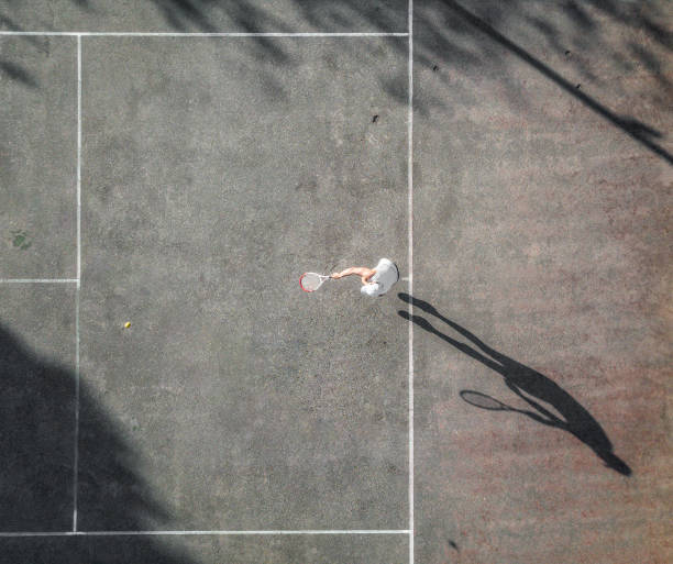 istock drone view over tennis player in afternoon sun 1090966826