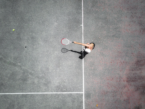 Drone view over tennis court with men playing