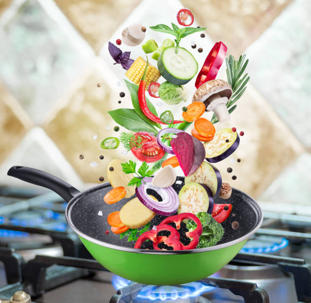 istock Flying fresh vegetables and spices falling into a pan. 1090972212