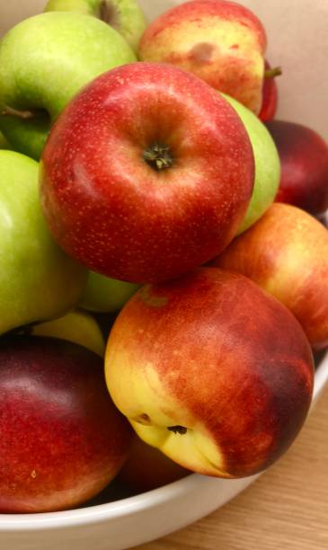 istock Image of green and red apples in fruit bowl with nectarines 1090973288