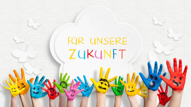 colorful painted hands in front of a decorated wall with the sentence "For our future" in German colorful painted hands in front of a decorated wall with the sentence "For our future" in German childrens day photos stock pictures, royalty-free photos & images