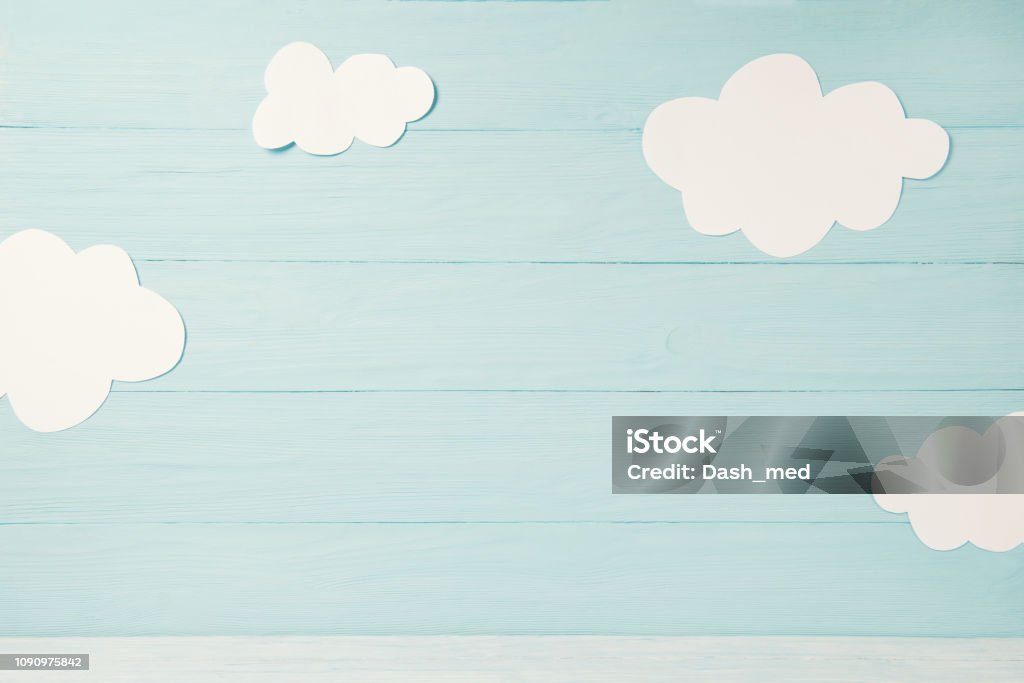 Cute children or baby card, white clouds on the light blue wooden background, tonned Cute children or baby card with white clouds on the light blue wooden background, toned Backgrounds Stock Photo
