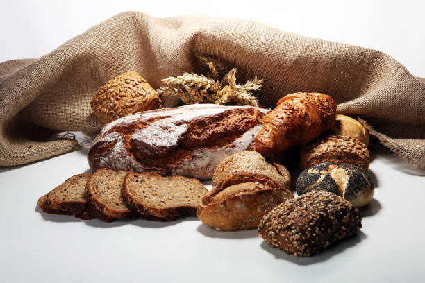 istock Different kinds of bread and bread rolls on board from above. 1090977238