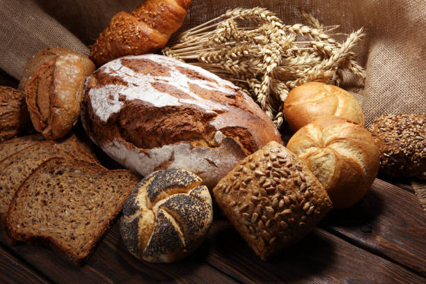 istock Different kinds of bread and bread rolls on board from above. 1090977720