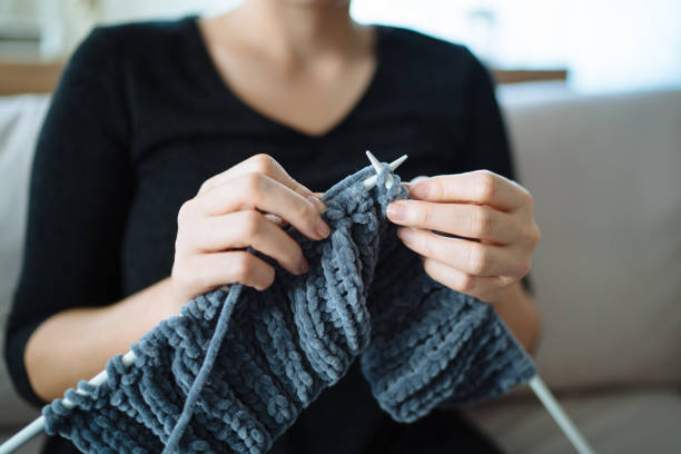 istock Close up on young woman's hands knitting 1090978450