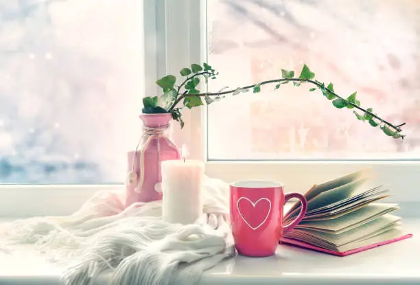 Photo of Valentine's day background,mug on window still.Comfort winter life style.