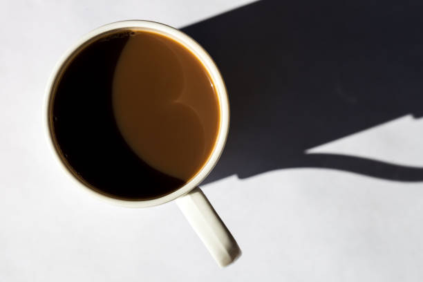 istock Minimalist composition of top view coffee cup with hard shadows on white textured background 1090982418
