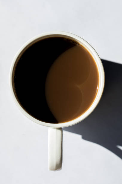 istock Minimalist composition of top view coffee cup with hard shadows on white textured background 1090982492