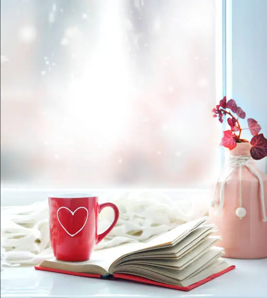 Photo of Valentine's day background,red mug on window still.