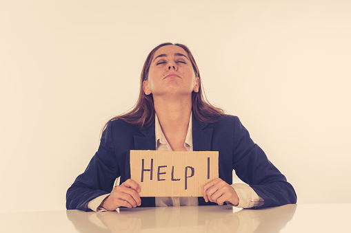 Young attractive depressed latin businesswoman holding help sign message exhausted under pressure and stress isolated on white in Unemployment Gender discrimination Depression and overwork concept.