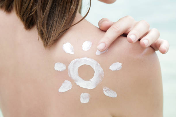 istock Woman with sun shaped sunscreen on her shoulder 1090992674