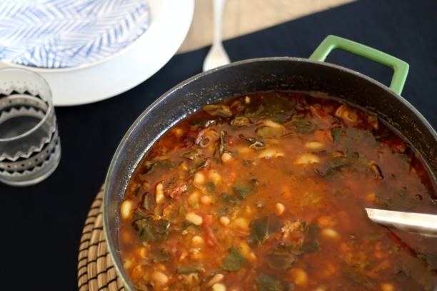 Minestrone Soup Large pot of minestrone soup with pasta, beans, dry meat and leaf vegetables. Selective focus. large pasta pot stock pictures, royalty-free photos & images