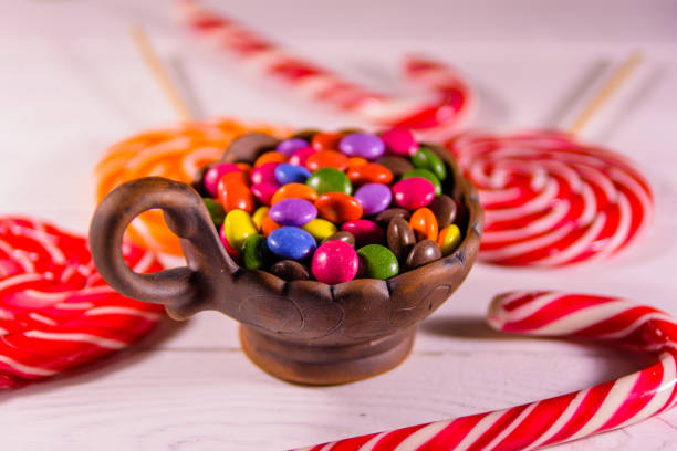 istock Ceramic bowl with colored candies and lollipops on a wooden table 1091019816