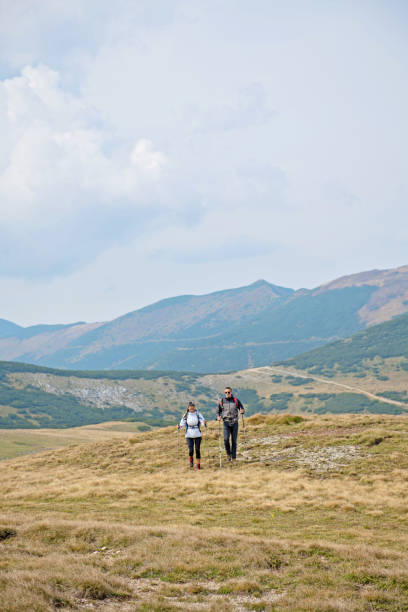 istock Sporty hikers on path with trekking poles 1091033134