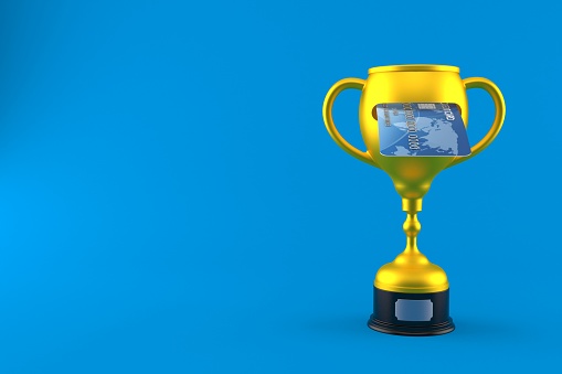 Golden trophy with credit card isolated on blue background. 3d illustration