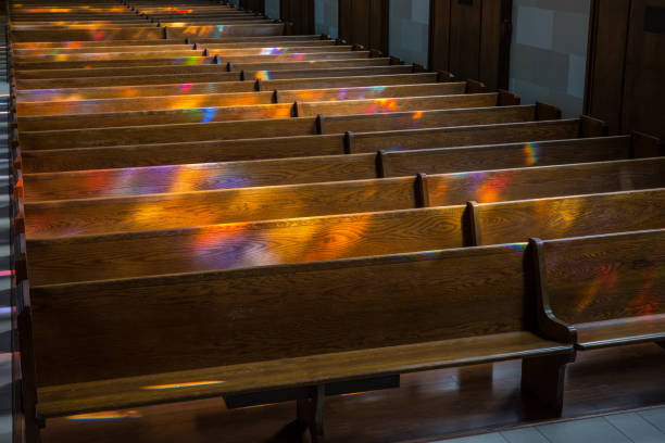 All Together As One Chapel pews with stained glass reflections.  Even though we're all different, we're all together as one. pew stock pictures, royalty-free photos & images