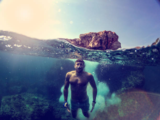 istock Man jumping into water from rocks WILD 1091047986