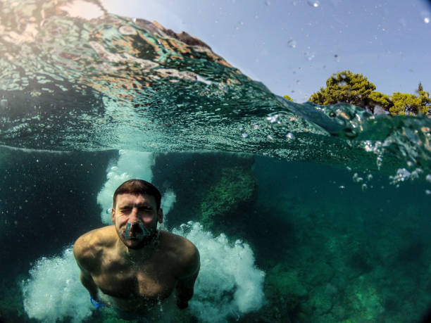 istock Awesome Man jumping into water from rocks WILD 1091048010