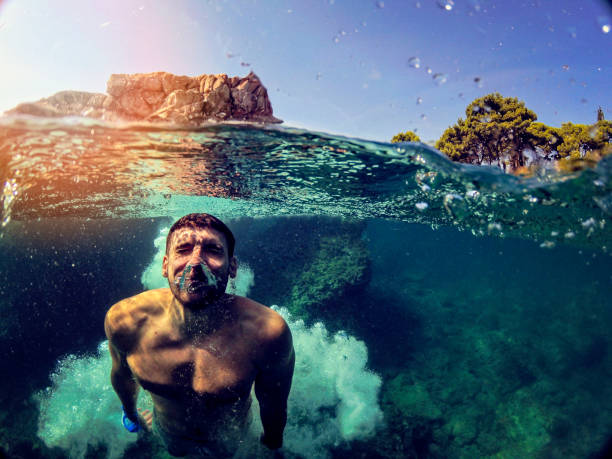 istock Awesome Man jumping into water from rocks WILD 1091048018