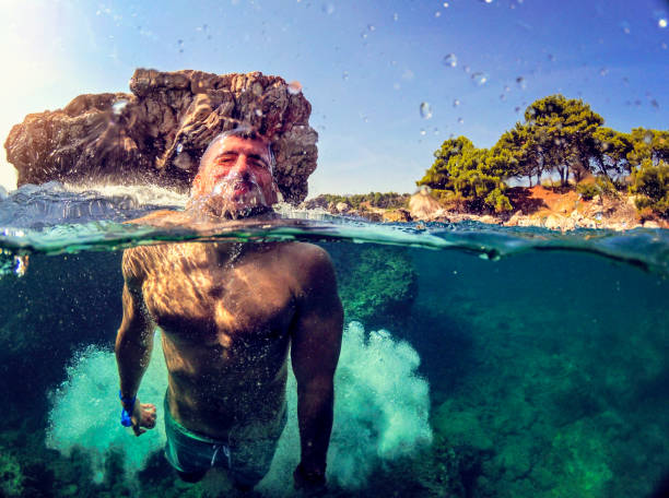 istock Awesome Man jumping into water from rocks WILD 1091048034