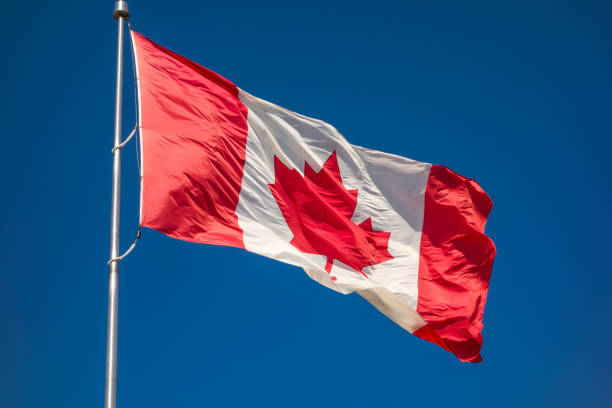istock Canadian flag against blue sky 1091050012