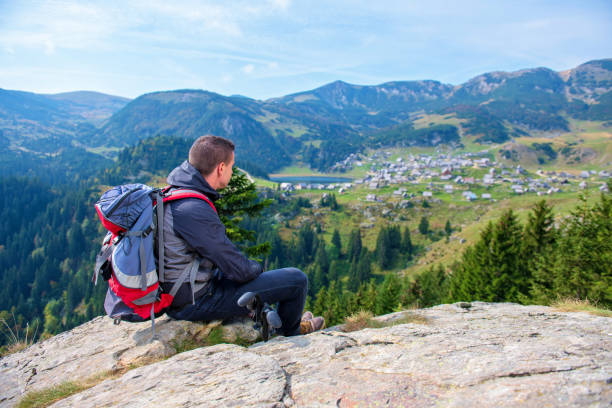 istock Young male hiker with backpack relaxing on top of a mountain during calm summer day. 1091050310