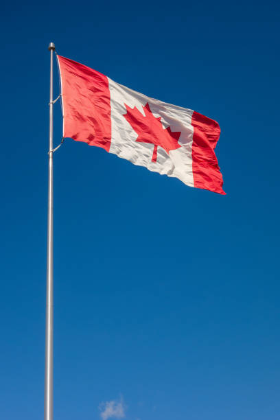 istock Canadian flag against blue sky 1091051830