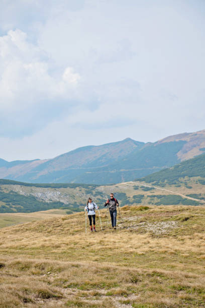 istock Sporty hikers on path with trekking poles 1091052766