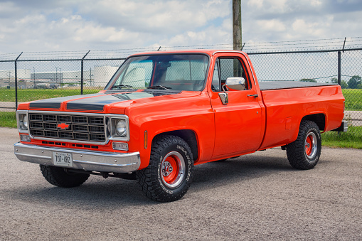 A red colored, vintage, 1978 Chevrolet C/K pickup truck with Ontario license plate is parked in a parking lot in Hamilton, Ontario, Canada.