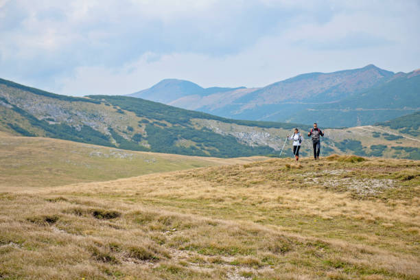istock Sporty hikers on path with trekking poles 1091059272