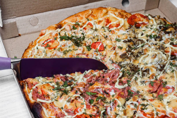 istock Pizza in a cardboard box. Shut. Pizza delivery. Pizza menu. Knife cuts pizza 1091079886