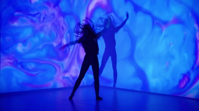 Multicolor background projection upon a female dancer