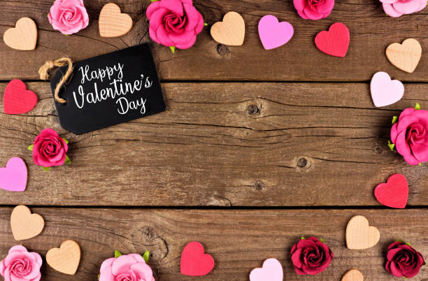 istock Happy Valentines Day frame with gift tag, hearts and roses against rustic wood 1091107268